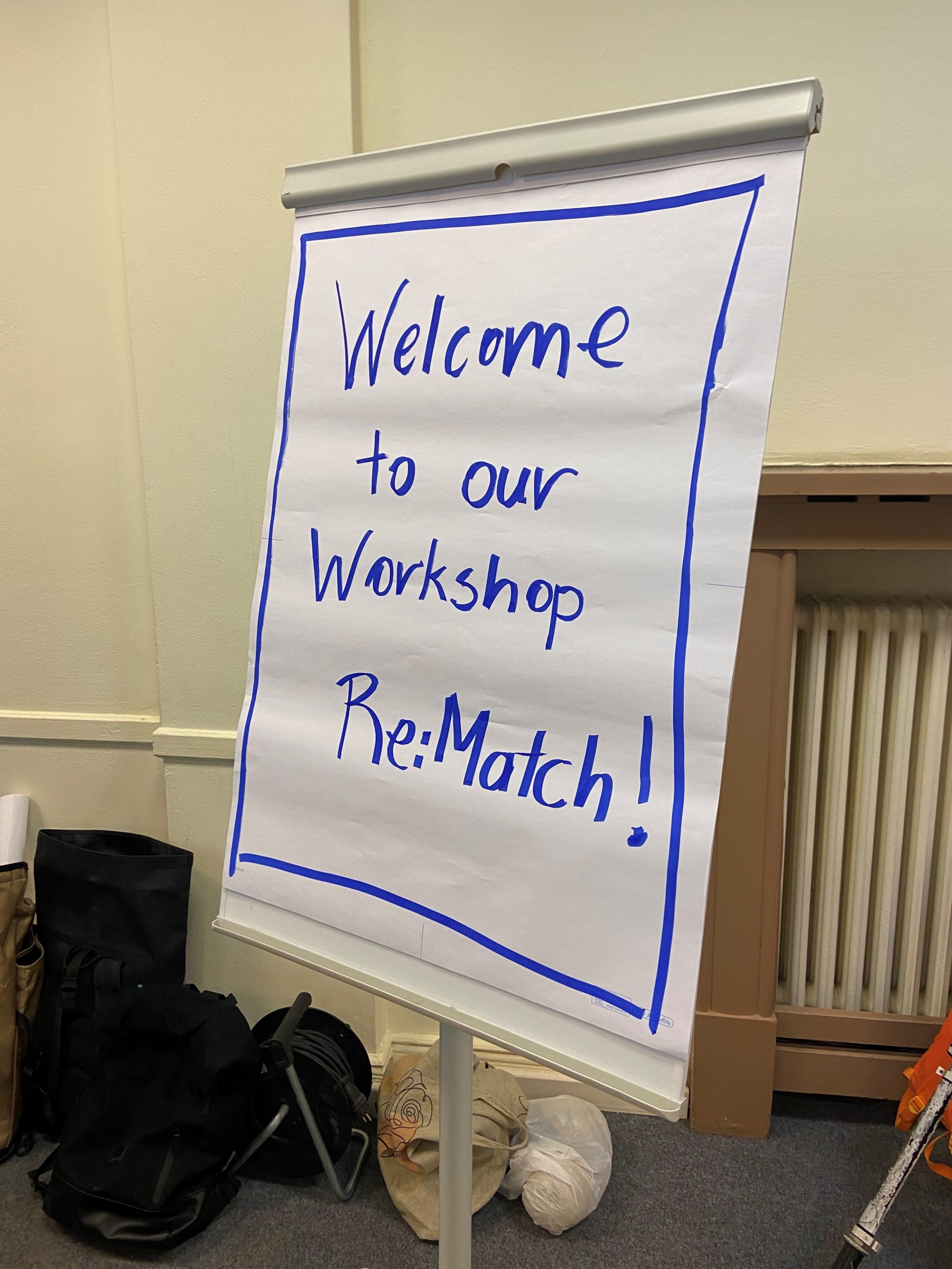 Ein Foto eines Workshops im Migrationsprojekt Re:Match der Berlin Governance Platform. Auf der Leinwand steht: Willkommen zu unserem Workshop Re:Match!